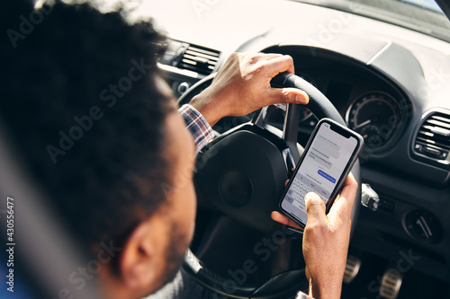 Canvas Print Dangerous Driving From Man Texting On Mobile Phone With One Hand On Steering Whe