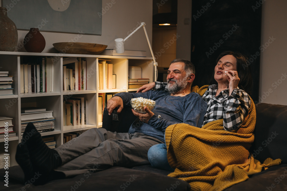 middle age couple relaxing at home watching television middle age couple relaxing at home watching television
