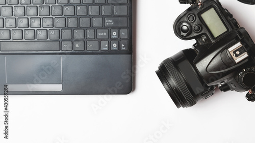 Digital camera and laptop. workplace photographer concept. white background