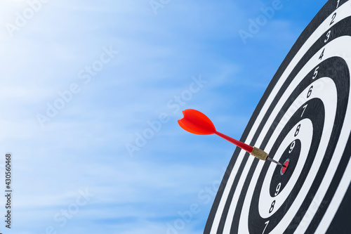 Bullseye is a target of business. Dart is an opportunity and Dartboard is the target and goal. challenge in business marketing business success concept. blue sky background