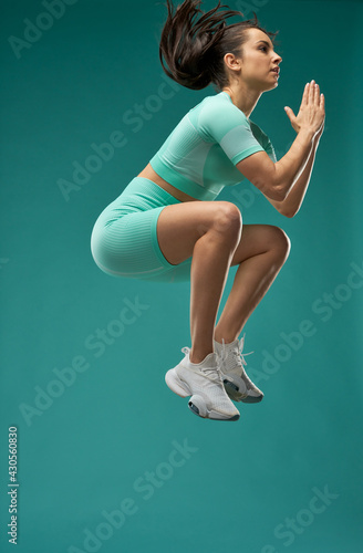 Attractive young woman in sportswear jumping in the air