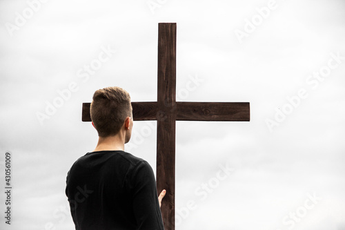 A man near the cross. Man believes in God. Hope in God