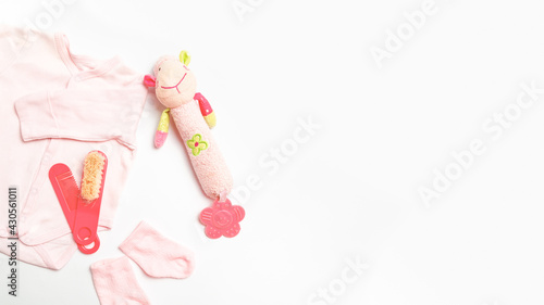 Hygiene items for the child. Baby care accessories. Set of child clothers bodusuit and socks, booties, toy. Top view. Flat lay. Copy space