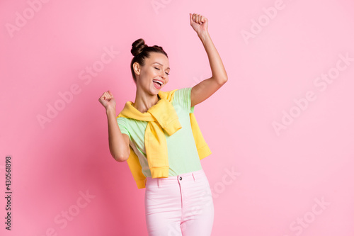 Photo of positive happy woman achieve dream raise fists closed eyes isolated pastel pink color background