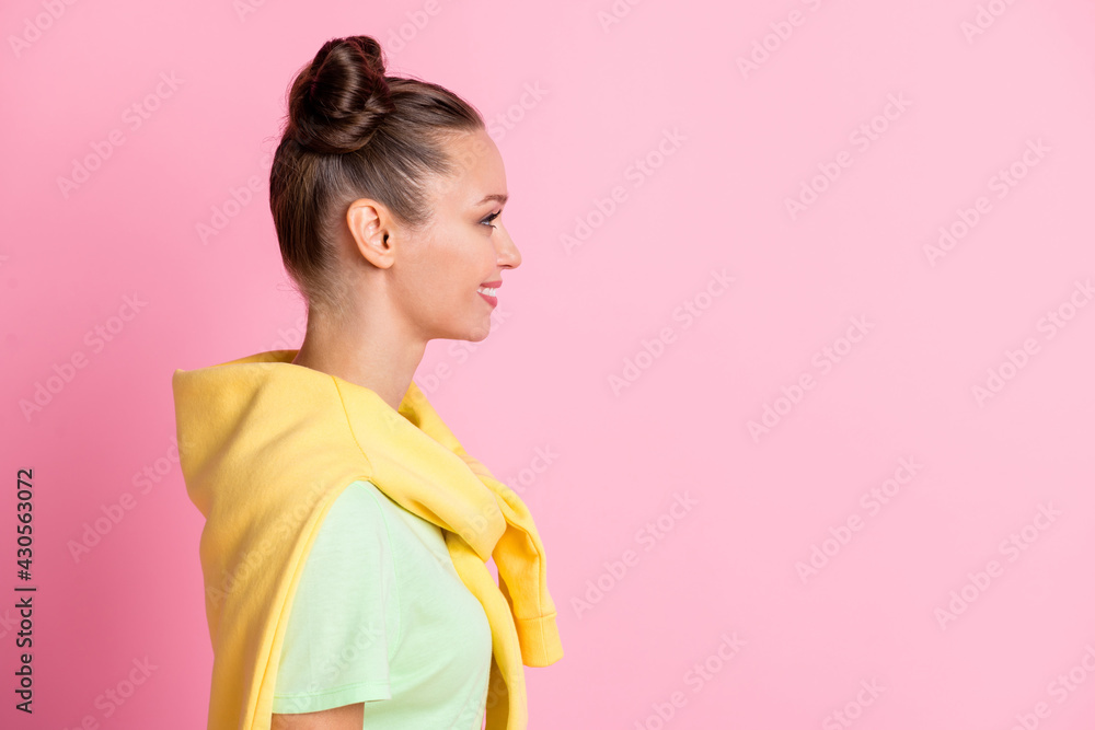 Profile side photo of positive cheerful girl look empty space good mood isolated on pastel pink color background Profile side photo of positive cheerful girl look empty space good mood isolated on pastel pink color background