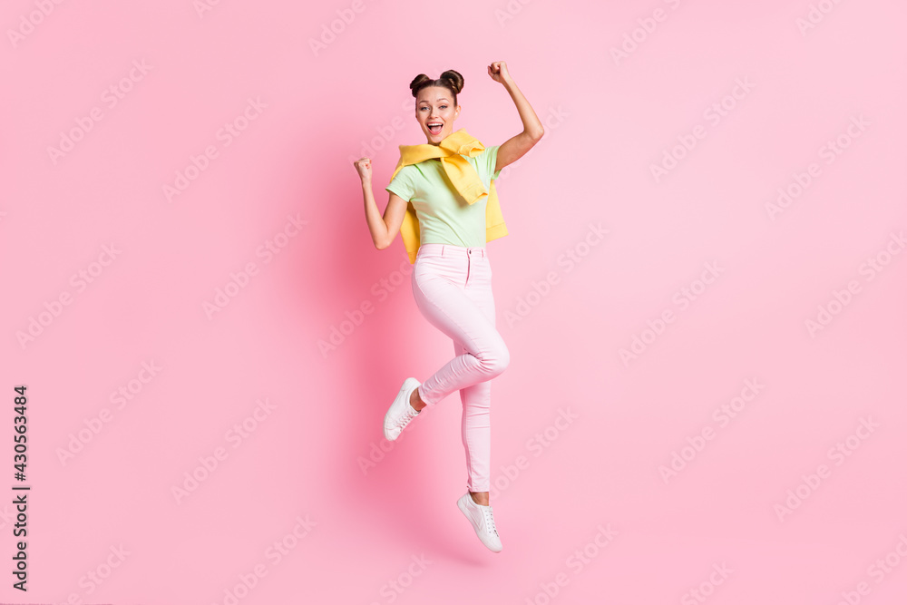 Photo of adorable lucky young lady dressed green t-shirt jumping high rising fists isolated pink color background Photo of adorable lucky young lady dressed green t-shirt jumping high rising fists isolated pink color background