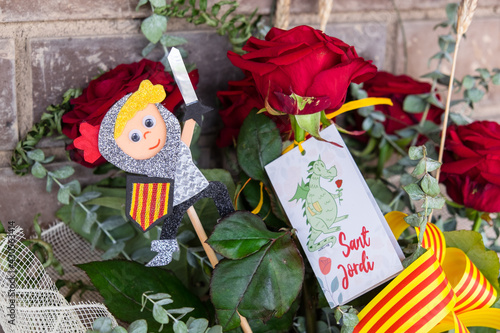 Tarragona, Spain - April 28, 2021: Roses with a Sant Jordi figurine to celebrate Sant Jordi day, the day of the book and the rose in Catalonia. photo
