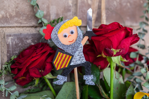 Tarragona, Spain - April 28, 2021: Roses with a Sant Jordi figurine to celebrate Sant Jordi day, the day of the book and the rose in Catalonia. photo