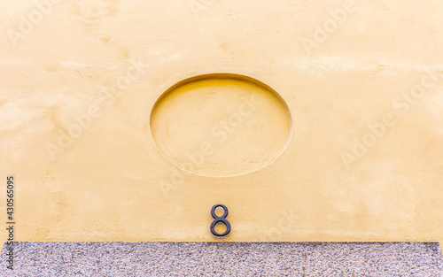 House number above the entrance on yellow facade