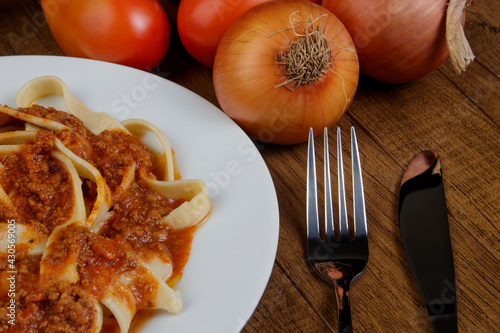Pasta with bolognese sauce. Tasty handmade Tagliatelle Pasta served on a white plate. Gastronomic close-up photograph.