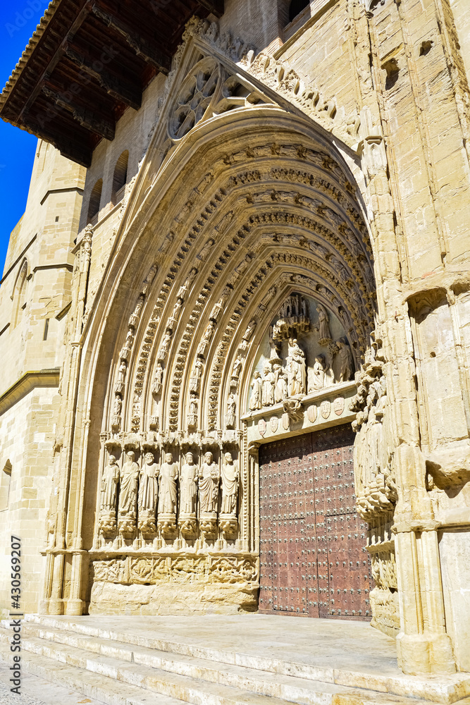 Gothic style arch of the Santa Iglesia Catedral in Huesca, Aragón. The main door of the cathedral in a sunny day with blue sky.