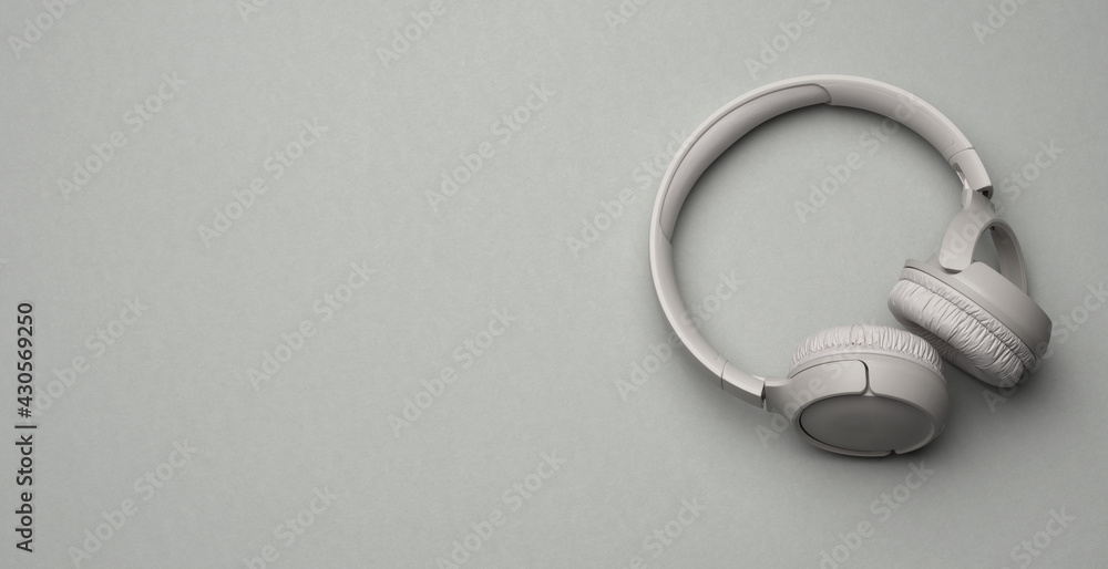 gray wireless headphones on a pink background, banner gray wireless headphones on a pink background, banner