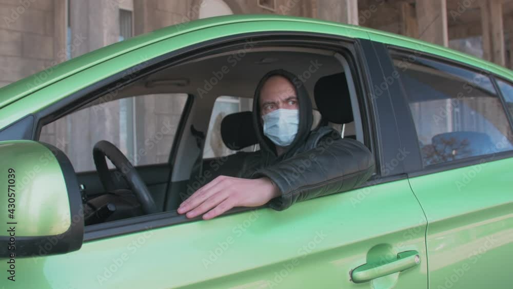 A man sitting in a car and taking a photo with a professional camera, a private detective or a paparazzi spy. A man sitting in a car and taking a photo with a professional camera, a private detective or a paparazzi spy.
