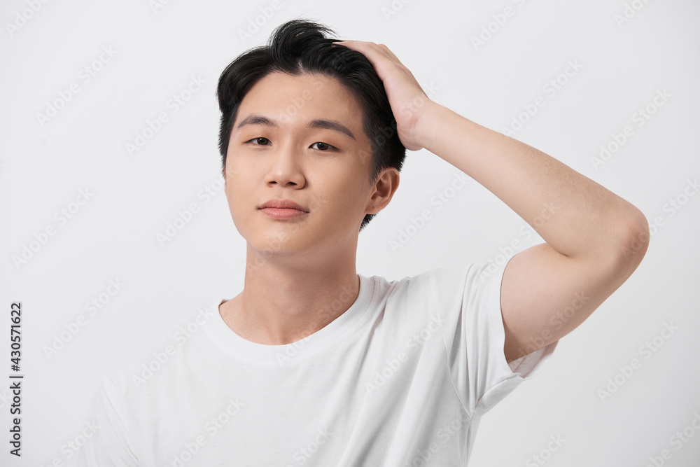 Young handsome man wearing white t-shirt over isolated background Smiling confident touching hair with hand up gesture Young handsome man wearing white t-shirt over isolated background Smiling confident touching hair with hand up gesture