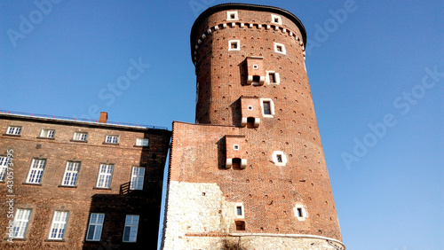 Entrance to the castle. Couple walking on the street. Scenic view of the old town country on a sunny day. Beautiful scape with medieval castle. Group of young people sightseeing famous Krakow landmark