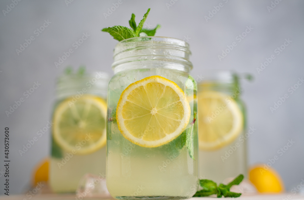 three Lemon mojito cocktail with mint in mason jars on top of wood. lemon mojito three Lemon mojito cocktail with mint in mason jars on top of wood. lemon mojito
