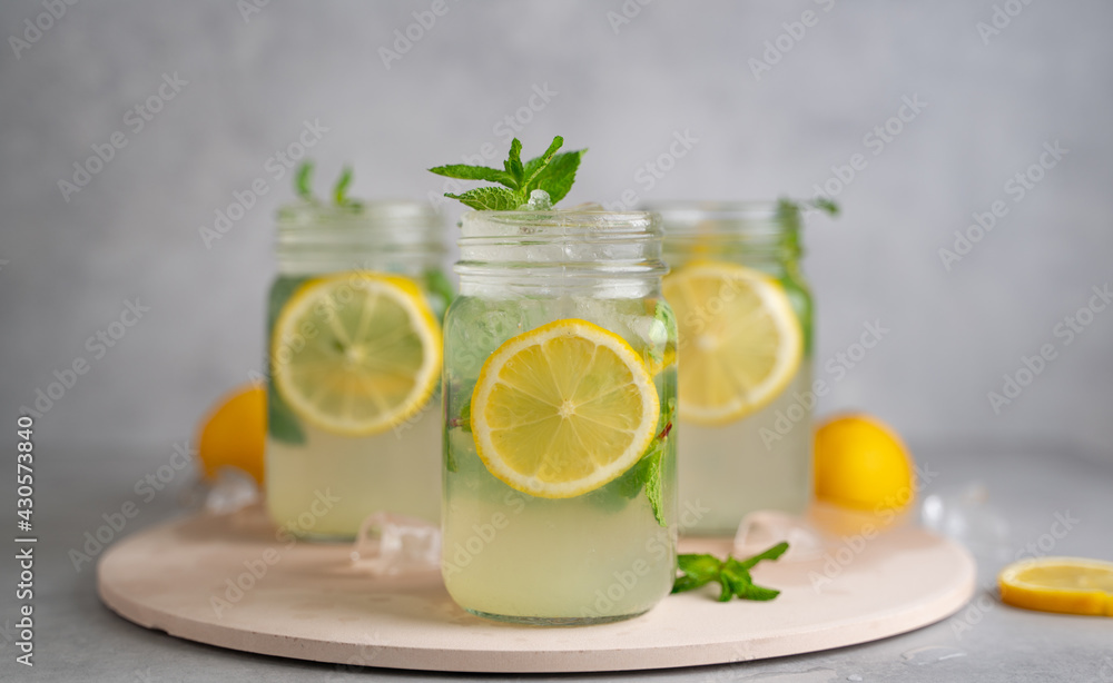 three Lemon mojito cocktail with mint in mason jars on top of wood. lemon mojito three Lemon mojito cocktail with mint in mason jars on top of wood. lemon mojito