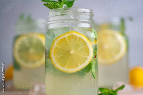 three Lemon mojito cocktail with mint in mason jars on top of wood. lemon mojito © MSM