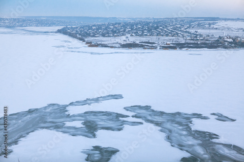 Landscape of frozen lake . Winter panorama with coastal village 