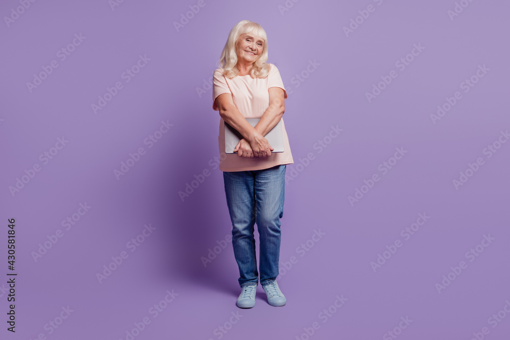 Beautiful old woman carry laptop on purple background Beautiful old woman carry laptop on purple background