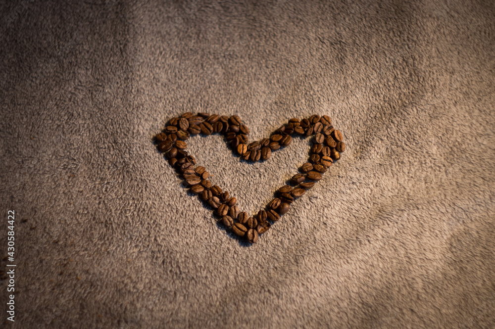 heart arranged from delicious black coffee on a soft background in the middle of the photo