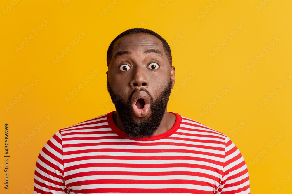 Headshot of surprised bug-eyed young dark-skinned man open mouth crazy face Headshot of surprised bug-eyed young dark-skinned man open mouth crazy face
