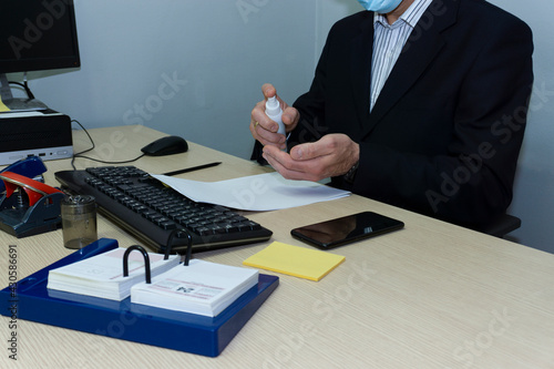 Hombre de negocios usando gel hidroalcoholico en la oficina photo