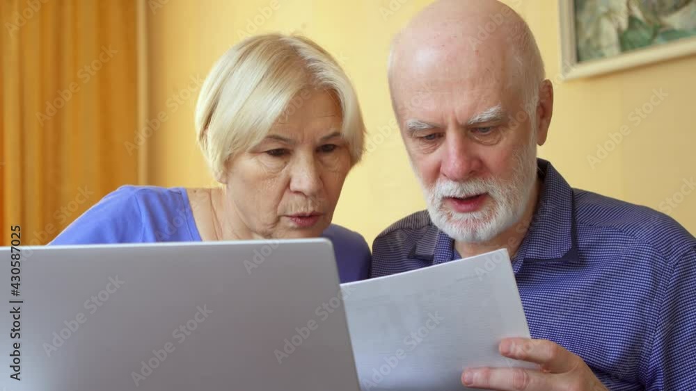 Senior couple working from home office on laptop. Family of retired pensioners with tax report docs Senior couple working from home office on laptop. Family of retired pensioners with tax report docs