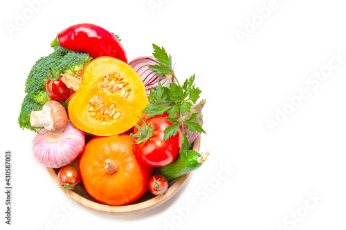 Set of fresh vegetables in a wooden bowl close-up. On a white isolated background. View from above. Healthy food concept. Copy space.