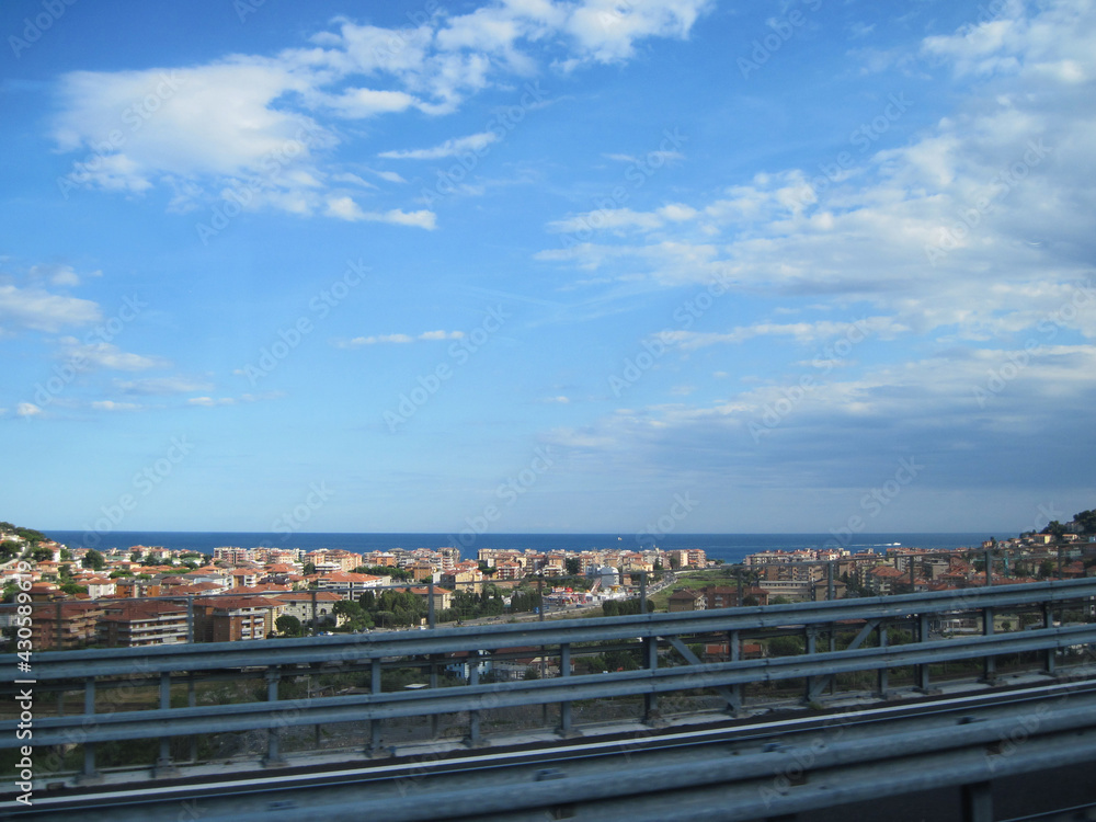 The road with panoramic view near Mediterranean Sea on a sunny summer day. Scenic landscape with autobahn traffic and morning blue sky.