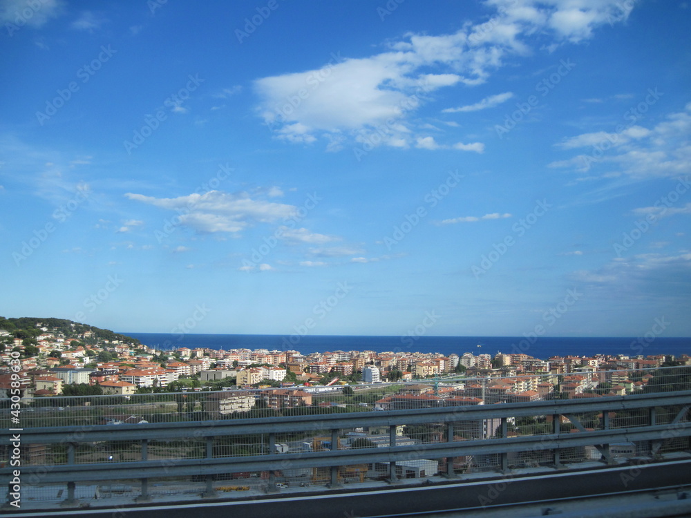 The road with panoramic view near Mediterranean Sea on a sunny summer day. Scenic landscape with autobahn traffic and morning blue sky.