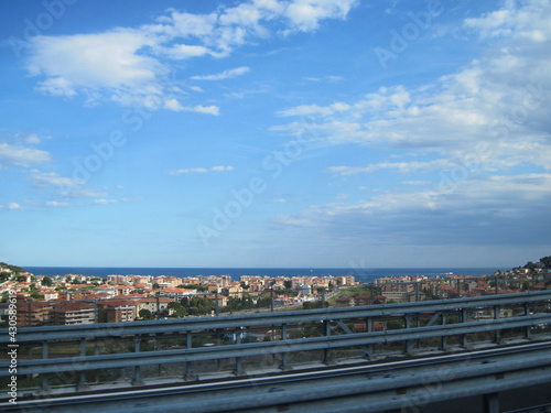 The road with panoramic view near Mediterranean Sea on a sunny summer day. Scenic landscape with autobahn traffic and morning blue sky. © Liudmyla Leshchynets