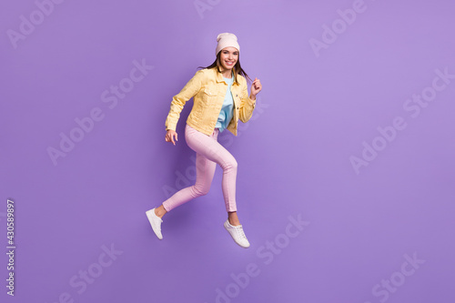 Full length body size photo of young woman jumping running fast isolated on vivid purple color background