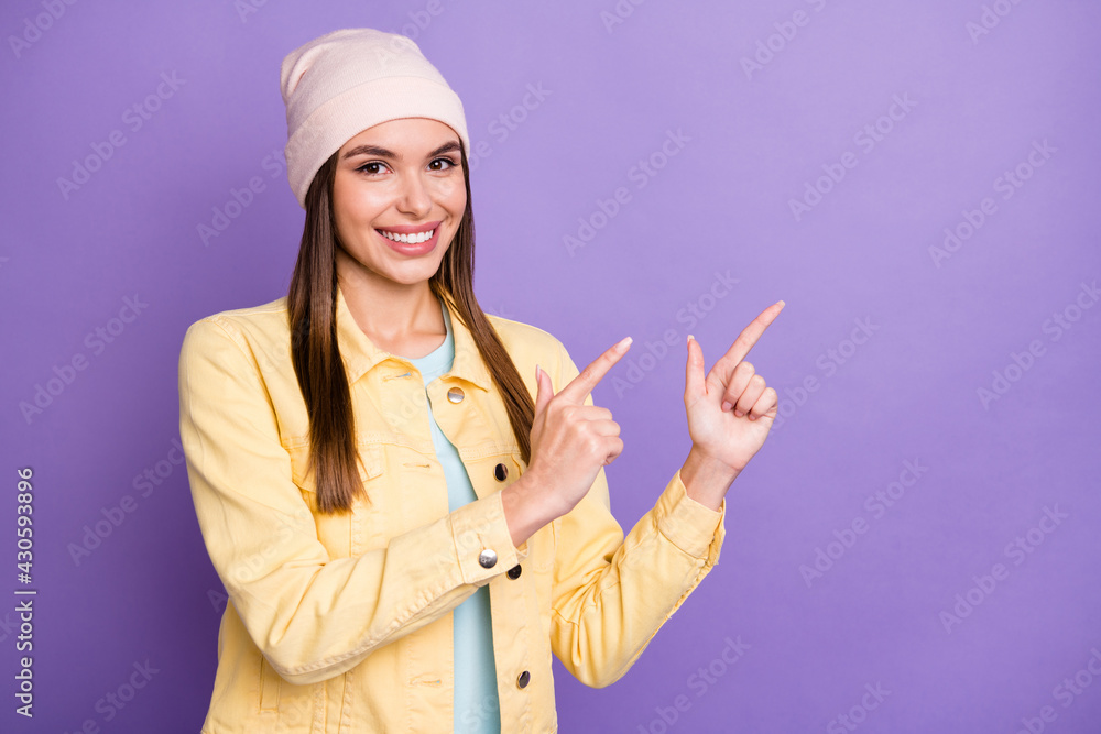 Portrait of optimistic straight hairdo girl point empty space wear cap jacket isolated on purple color background Portrait of optimistic straight hairdo girl point empty space wear cap jacket isolated on purple color background