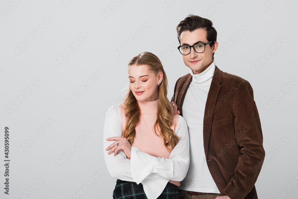 smiling man in brown jacket standing near shy woman isolated on grey smiling man in brown jacket standing near shy woman isolated on grey