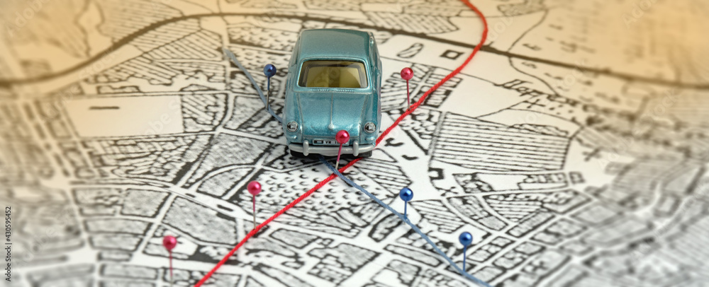 City map, blue toy car. Two routes are marked with pins: red and blue ...
