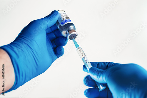 Injecting dose of generic vaccine in syringe for infections prevention in white background.Doctor preparing vial of vaccine generic free injection for the vaccination plan against diseases global