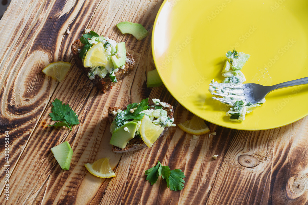 Make avocado paste sandwiches with sprouted green buckwheat and lemon on rye bread with a fork Make avocado paste sandwiches with sprouted green buckwheat and lemon on rye bread with a fork