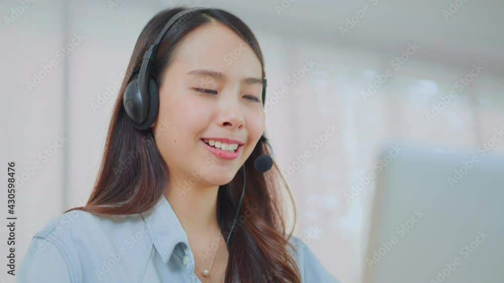 Close-up shot of Asian female call center agent talking to customer. Close-up shot of Asian female call center agent talking to customer.
