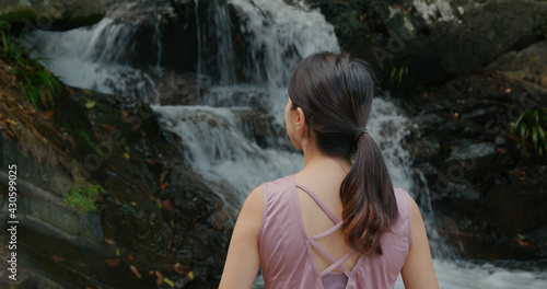 Woman enjoy the waterfall in forest