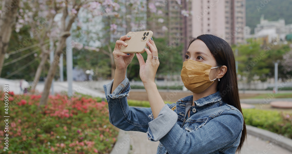 Woman wear face mask and use of smart phone to take photo