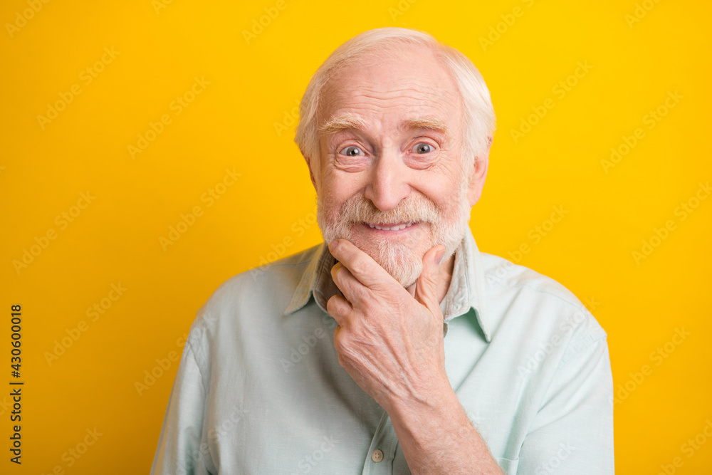 Photo of positive smart mature man dressed green shirt arm chin smiling isolated yellow color background Photo of positive smart mature man dressed green shirt arm chin smiling isolated yellow color background