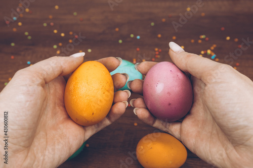 Easter eggs in hand. Eggs in the background lie on a wooden table.Easter background.