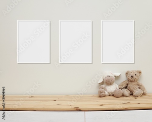 3 blank vertical frames mockup on wall for nursery wall art display, baby room three white frames mock up, wooden shelf, soft toys on shelf.