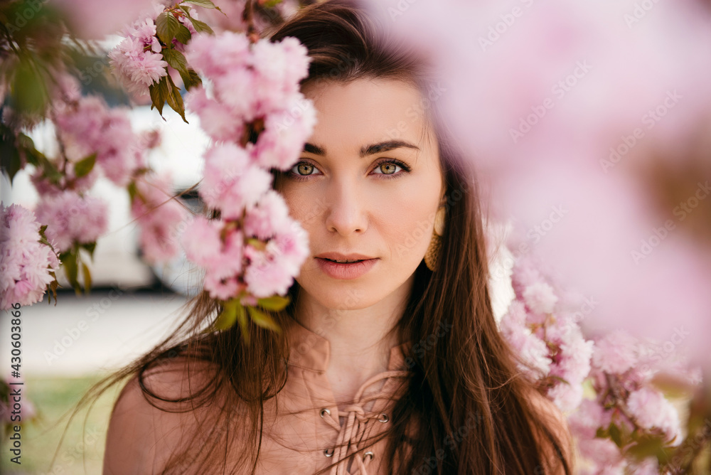 Girl face portrait under blossom sakura flowers