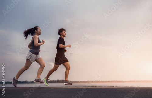 Young couple running on the street be running for exercise. Athletes running fitness to stay healthy. running and lifestyle concept.