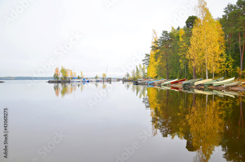 Beautiful reflection of boas and autumn forest on the lake, close to sauna of Rauhaniemi, Tampere, Finland