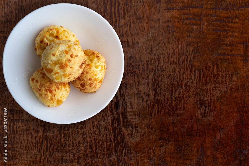 Bowl with cheese bread (typical of Minas Gerais - Brazilian state) on wooden table. Bowl with cheese bread (typical of Minas Gerais - Brazilian state) on wooden table.