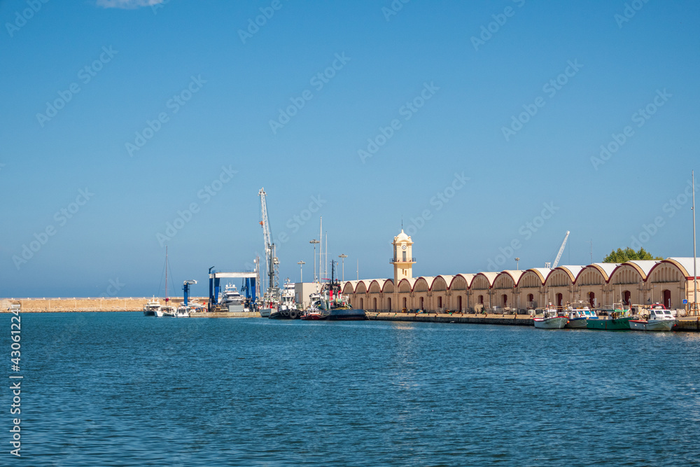 Views of the port of Gandia, with the sheds, warehouses and the fish market., on a sunny day.