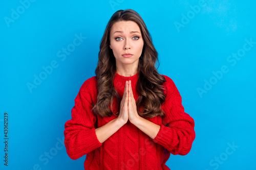 Portrait of attractive girlish girl pleading forgiveness isolated over vibrant blue color background